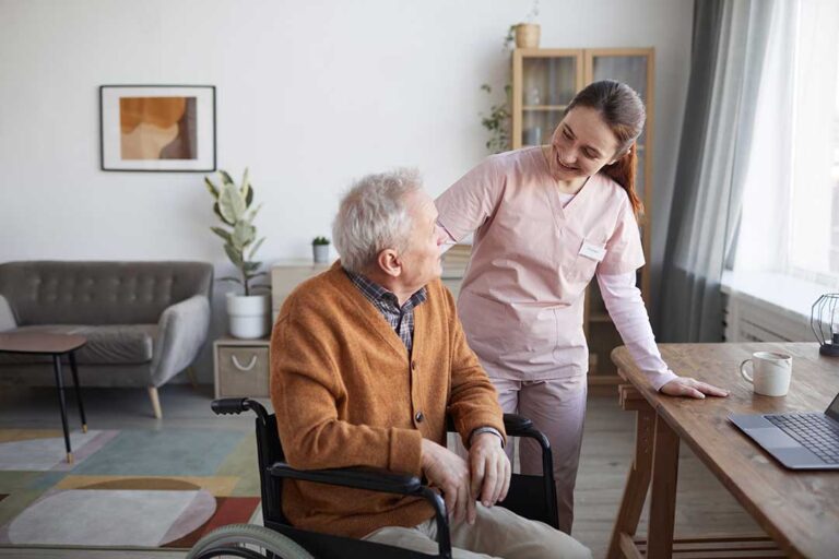 A senior and a family member reviewing legal documents together at a table with pens and folders.
