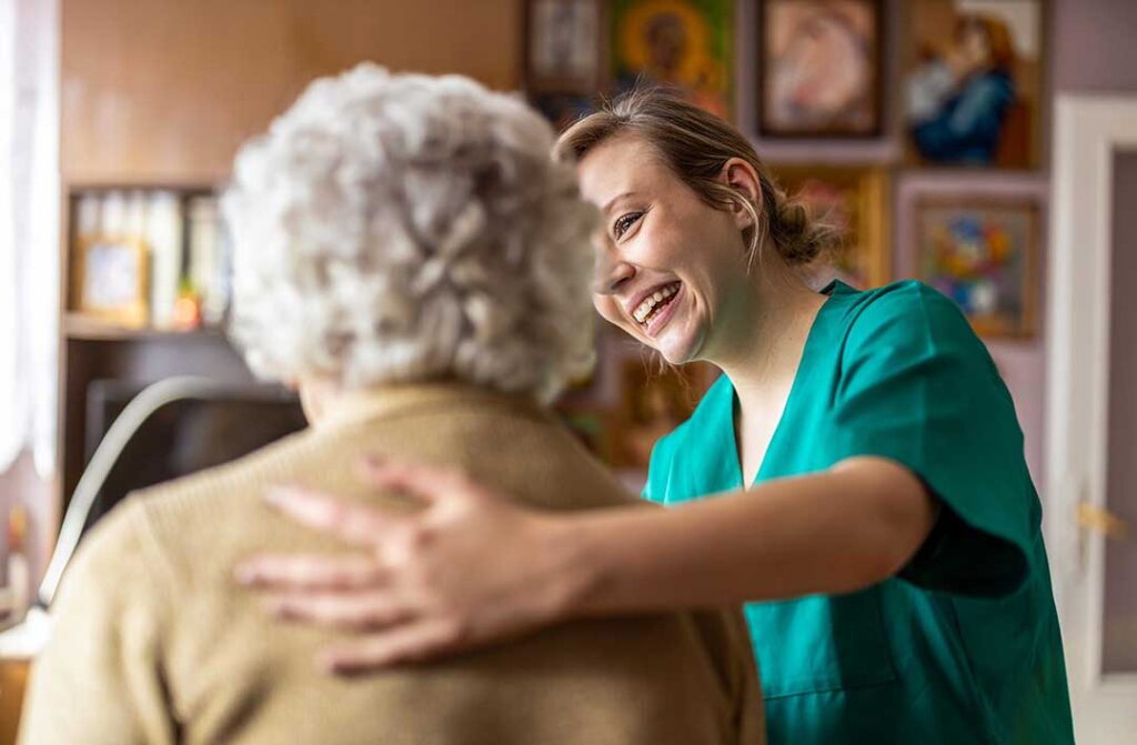 Older adult and family caregiver reviewing a short-term assisted living room with personal belongings nearby