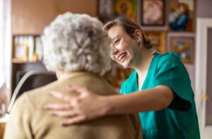 Older adult and family caregiver reviewing a short-term assisted living room with personal belongings nearby